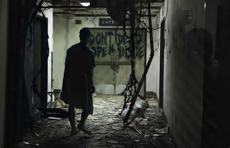 a man standing in an alley with graffiti on the walls and door to ...