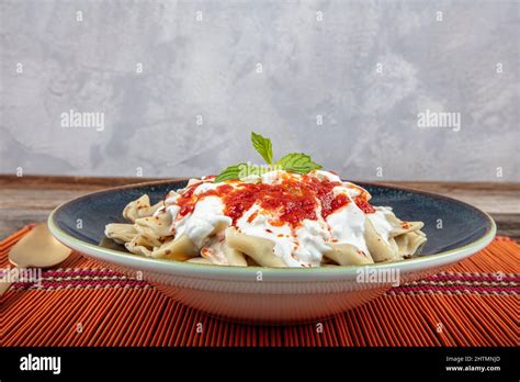 Plates of traditional Turkish food. Turkish Ravioli (Mantı) with yoghurt and tomato sauce Stock ...