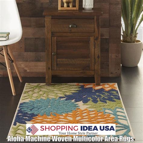 an area rug with flowers on it in front of a wooden table and white chair