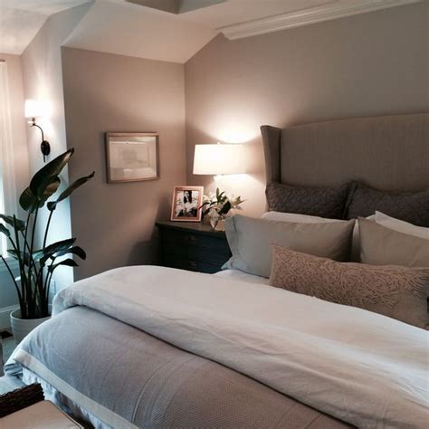 a taupe bedroom with taupe walls, an upholstered bed, dark stained ...