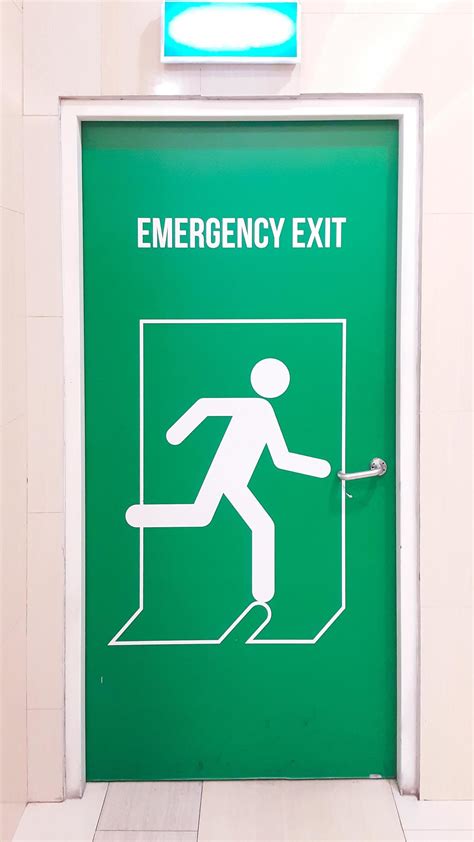 A green emergency exit door in the shopping mall building. Portrait ...