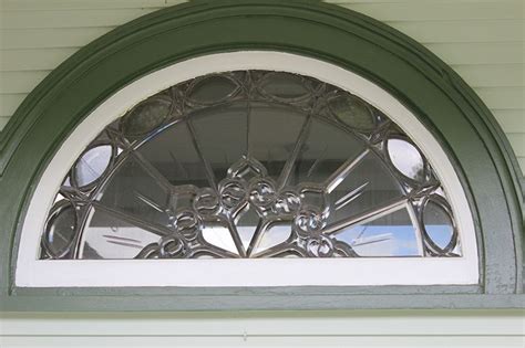 a close up of a window on the side of a white house with green trim