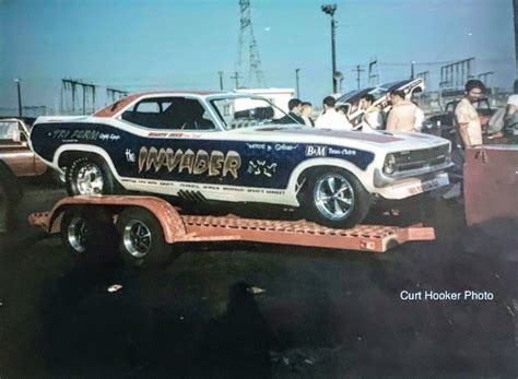 an old photo of a car being towed by a flatbed tow truck with people ...