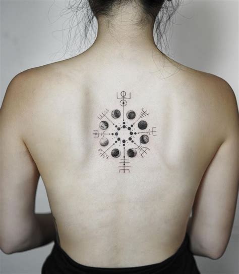 Icelandic symbol Vegvisir tattoo with moon phases inked on the center of the upper back ...