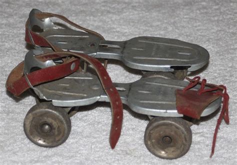 an old metal toy roller skate with two wheels and red laces on the bottom