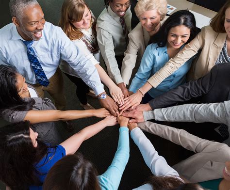 Diverse team of professionals with hands in teamwork huddle - GMS ...