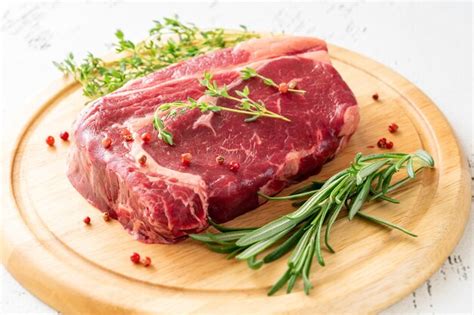 Premium Photo | Raw rib eye beef steak with thyme and rosemary