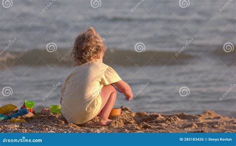 Back View of a Little Girl Plays with Colored Toys on the Beach. Stock Footage - Video of ...