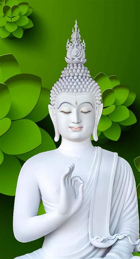 a white buddha statue sitting on top of a lush green field with lots of leaves