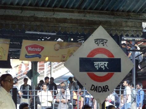 there is a sign that says dadar on it in front of people standing around