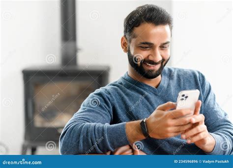 Smiling Indian Guy Wearing Casual Outfit Messaging, Texting on the Smartphone Stock Photo ...