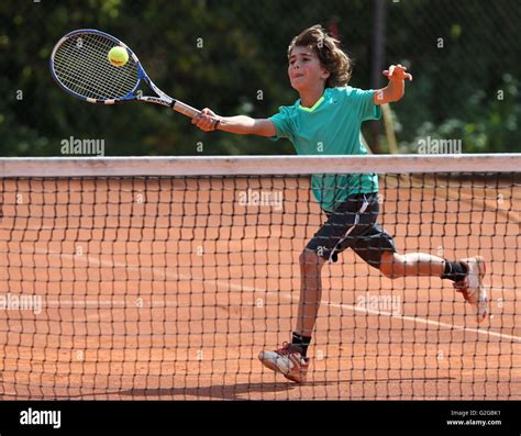 Boy, 10, playing tennis, hitting a forehand volley, Munich, Upper ...