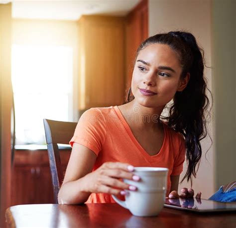 Coffee and Her Tablet Equal Relaxation. a Smiling Young Woman Sitting at Her Dining Table at ...