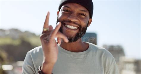 Hand, Happy and Sign with a Black Man Showing a Gesture while Standing Outdoor in the City with ...