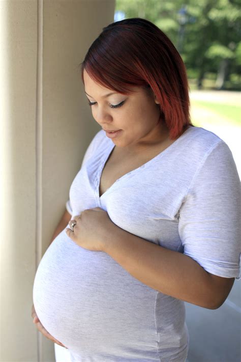 pregnant woman holds her tummy and looks at it - WorkLife Law