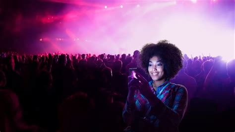 A fan enjoying a differentiated 5G experience on her smartphone at a ...