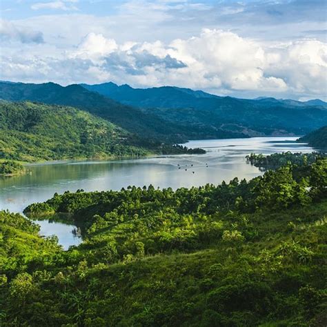 an aerial view of a lake surrounded by lush green trees and mountains ...