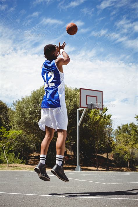 Teenage basketball player scoring while practicing in court Stock Photo ...