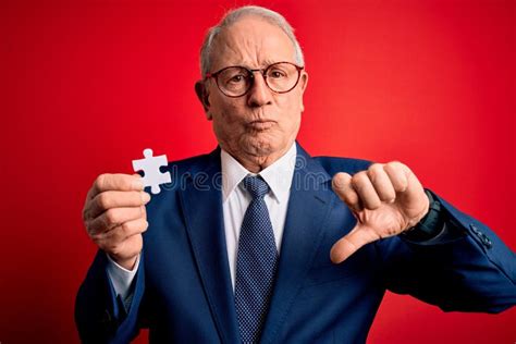 Grey Haired Senior Business Man Holding Puzzle Piece As Union and Cooperation with Angry Face ...