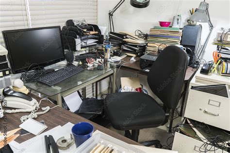 Messy business office desk with piles of files and disorganized clutter ...