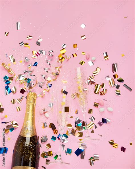 Champagne bottle with confetti on pink background. Stock Photo | Adobe Stock