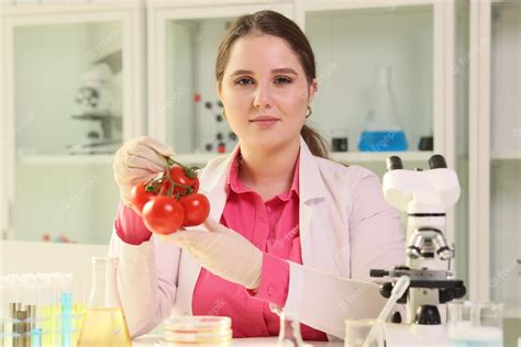 Premium Photo | Portrait of young woman scientist holding tomatoes in hands nitrates in ...