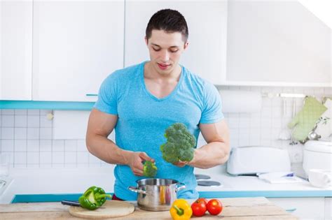 Premium Photo | Young man cooking healthy preparing meal vegetables in ...