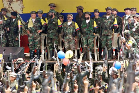 Leaders of the Armed Revolutionary Forces of Colombia watch a parade of armed fighters at a camp ...