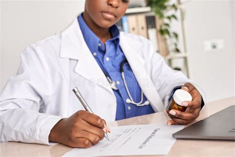 African American Doctor Writing Prescription Holding Pills Bottle Sit at Desk. Stock Photo ...