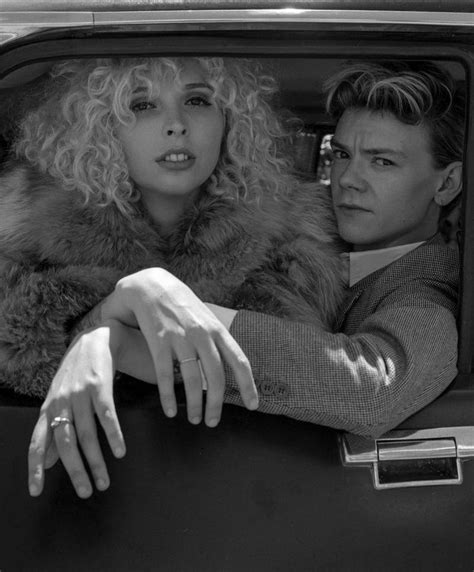 two women sitting in the back of a car with their hands on the door handle