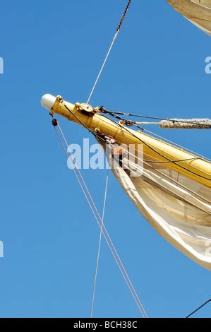 Sailboat yardarm with furled sail rigging and block and tackle Stock Photo - Alamy