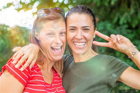 Two happy woman friends laughing together in a park with - stock photo ...