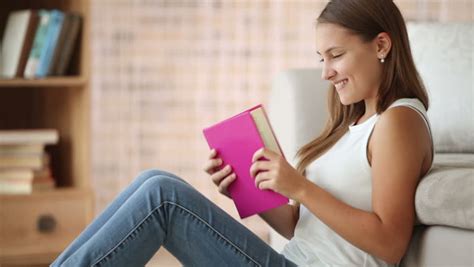 Cute Girl Sitting On Floor Reading Book Closing It And Smiling. Panning Camera Stock Footage ...