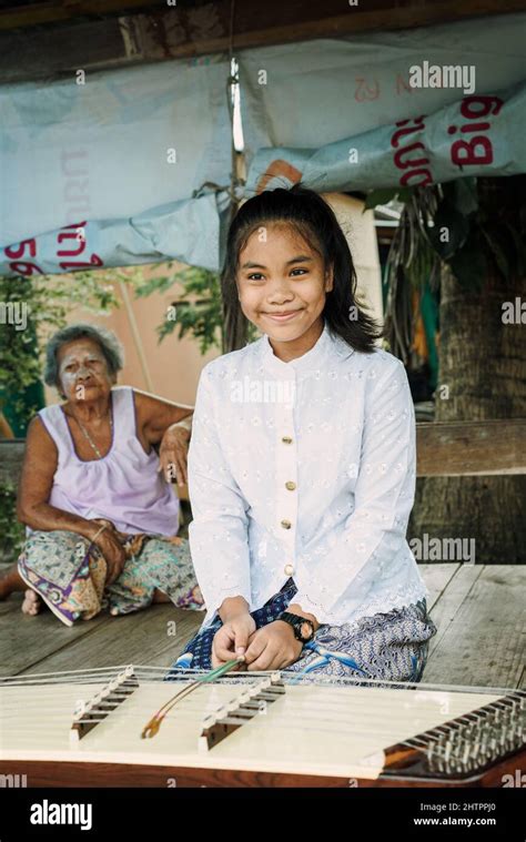 Beautiful Thai girl playing Khim traditional music instrument near grandmother Stock Photo - Alamy