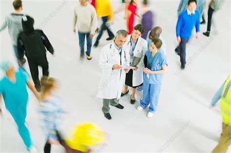 Bustling crowd around doctors and nurses - Stock Image - F014/6814 - Science Photo Library