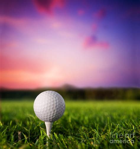 Golf ball on tee at sunset Photograph by Michal Bednarek - Pixels