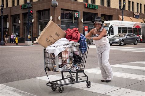 Homeless lady crossing the street with her shopping cart. by Matthew Davis. Photo stock - StudioNow