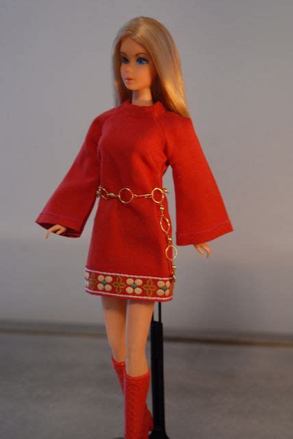 a barbie doll wearing a red dress with gold chains on it's waist and legs