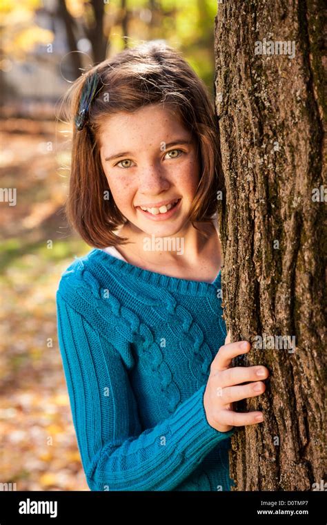 Young Girl Peeking around Tree, USA Stock Photo - Alamy