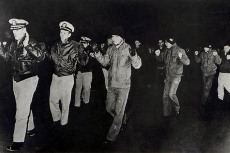 U.S. Navy crew members of the USS Pueblo hold up their hands while in ...