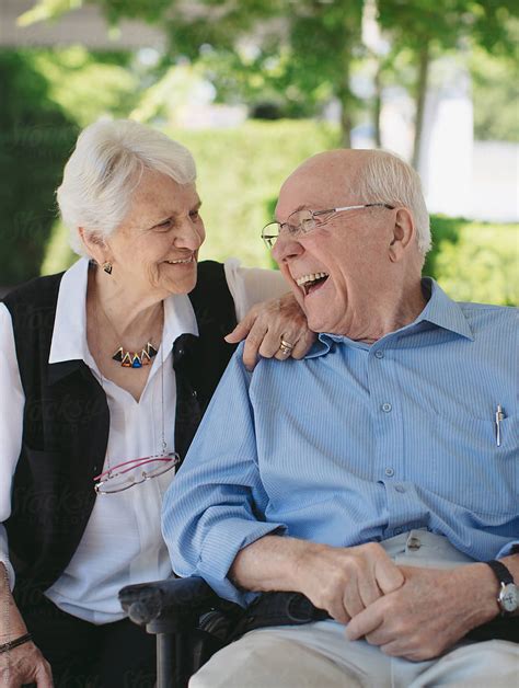 "Happy, Fun Loving Elderly Couple Outside In Garden Using Wheelchair ...