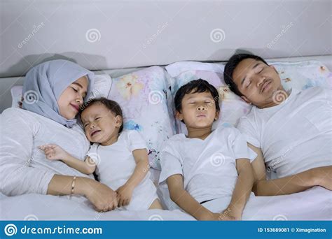 Young Parents Sleeping with Their Children on Bed Stock Image - Image of bedding, daughter ...