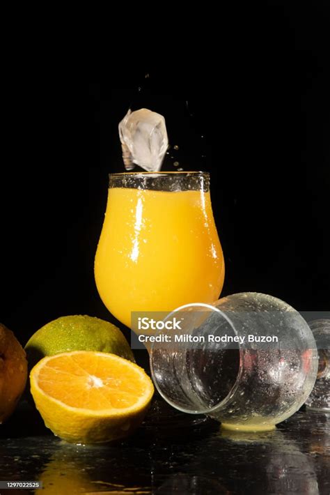 Orange Juice Ice Cube Falling Into A Beautiful Glass Of Orange Juice ...