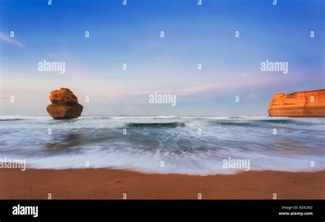 Warm sunrise over disconnected limestone apostle rock off Gibson steps beach at Great Ocean road ...