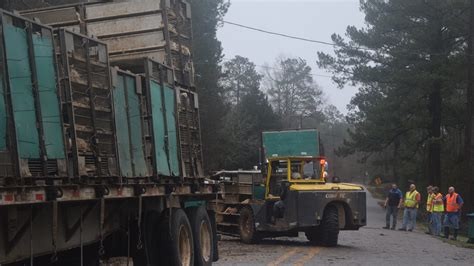 Workers clear the scene of a Mar-Jac Poultry truck rollover in Petal