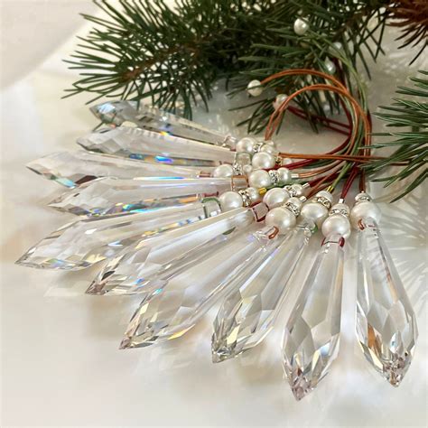 a christmas tree branch with some crystal beads and pine needles on it ...