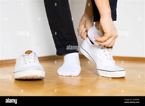 put on white sneaker shoes on wooden floor and white background Stock Photo - Alamy