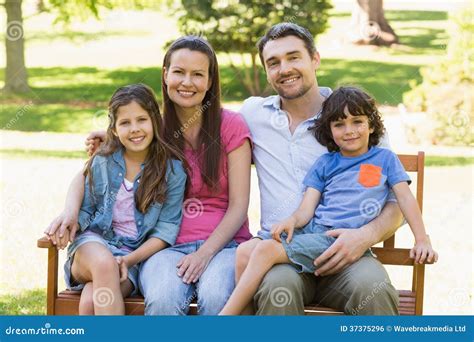 Couple With Young Kids Sitting On Park Bench Royalty Free Stock Image - Image: 37375296