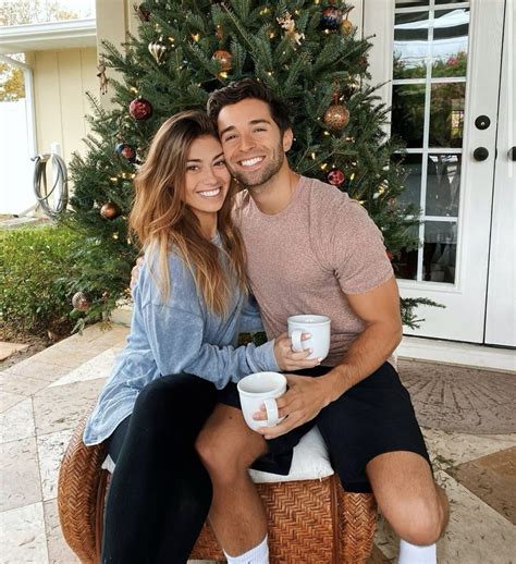 a man and woman sitting next to each other holding coffee cups