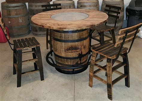 a table made out of wine barrels with chairs around it and two stools ...